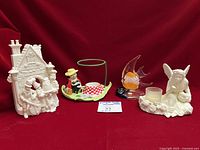 All four Partylite candle holders lined up on red backdrop