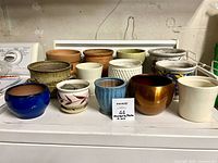 All 13 assorted pots arranged in two rows