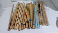 Photo showing 22 sticks including drumsticks and mallets sorted in a row, showing variety and quantity