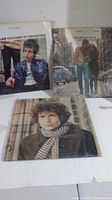 Three Bob Dylan vinyl records shown with album covers, arranged on a white surface.
