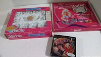 Photo showing the boxed Barbie China Tea Set, Barbie Fashion Fun Rubber Stamp Set, and mini plate with stand.