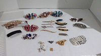 Photo showing all items including 18 hair clips, various brooches, and a bracelet laid out on a white surface.