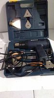 Heat gun, power cord and multiple metal nozzle attachments in blue carrying case