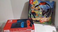 Nintendo Switch original console box front alongside Ring Fit Adventure box