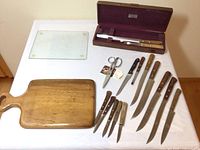 Full view of all the items spread on a white surface showing cutting boards, knife set, and kitchen shears.