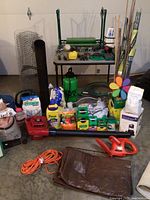 Photo showing full arrangement of gardening supplies including tools, chemicals, bags of sand, and accessories