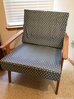 Front view of the teak armchair showing frame and cushions
