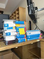 Stack of assorted HP photo paper boxes and Epson photo paper on desk