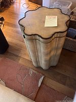 Top angle view of the Lexington drum table showing curved scalloped top and cream textured finish.