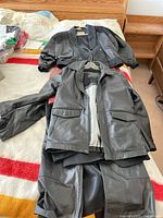 Photo of three coats including a Danier leather coat, black bomber jacket, and a MEXX suit below them.