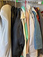 Eight coats hanging on rack showing different styles and colors including puffer jackets and wool blend coats