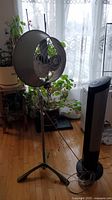 Photo showing Seville Classic Tower fan next to vintage Electrahome floor fan in room environment
