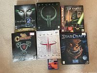 Overview of all seven boxed games including System Shock 2, Quake II, Jedi Knight, Camelot, Quake III Arena, StarCraft and Skunny Kart.
