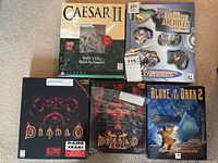 Photo showing all five video game boxes together: Caesar II, The LucasArts Archives Vol. III, Diablo Game of the Year Edition with original plastic cover, and Alone in the Dark 2.