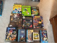 Overview of all eleven game boxes laid out on carpet