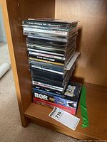 Stack of game cases and boxes showing titles such as Duke Nukem 3D Shareware, Sid Meier's Alpha Centauri, Sega Family Fun Pak, and Sonic the Hedgehog Genesis boxed game.