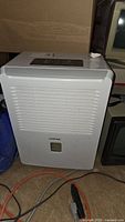 Full front view of the Kool King white dehumidifier showing air vent and water level window.