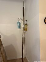 Full view of MCM tension pole lamp with two colored glass shades and missing third shade.