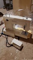 Off-white Kenmore sewing machine model 1233280 with foot pedal visible on beige carpet background.