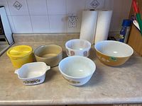 Full view of all bowls including Tupperware and Pyrex on kitchen counter