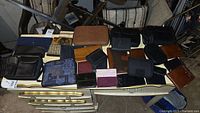 Lot of 18 various wallets and organizers in different colors and materials on a table