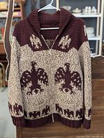 Front view showing maroon and cream colors with large eagle motifs and zipper closure.