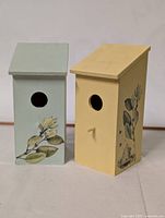 Front view of both bird houses showing entrance holes and decal details