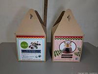 Two cardboard boxes of felt animal kits with carrying handles, showing branding and images of finished felt animals on the packaging.
