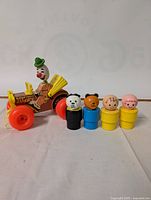 Full set showing the jalopy pull toy with clown figure and four peg characters with various animal and child heads.