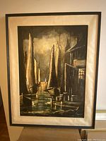 Full view of the antique oil painting in its frame, showing medieval harbor with boats and buildings in dark tones with gold highlights.