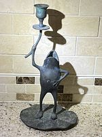 Bronze frog candle holder shown alone on counter with tile backsplash