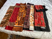 Full view of six folded scarves laid flat showing different colors and patterns