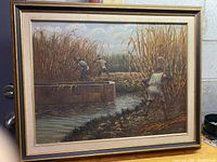 Frontal view of the framed painting showing the scene of people harvesting sugarcane by a water canal.