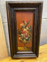 Full view of the framed vintage oil painting showing the floral arrangement and wood frame.