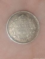 Reverse side of 1919 Canadian 5 cent coin showing denomination and crown.
