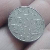 Reverse side of the 1928 Canadian 5 cents coin showing denomination, maple leaves, and year 1928.