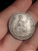 Front side of the 1937 large penny coin showing Britannia seated holding a trident with 'ONE PENNY' inscription and the year '1937'.