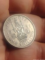 Reverse side of the coin showing the crowned lion on a crown with date 1951 and inscription 'ONE SHILLING'.