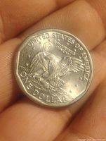 Reverse side of the 1979 Susan B. Anthony dollar coin showing an eagle landing on the moon, earth visible in the background, with inscriptions 'UNITED STATES OF AMERICA,' 'E PLURIBUS UNUM,' and 'ONE DOLLAR'.