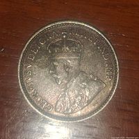 Obverse photo showing King George V portrait and inscriptions on 1929 Newfoundland silver 5 cent coin.