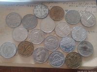 Top view of twenty assorted Canadian and US nickels, showing front side designs including beaver, Monticello, buffalo and Liberty head images.