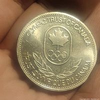 Obverse side showing Olympic Trust of Canada emblem with maple leaf and Olympic rings surrounded by bilingual text.