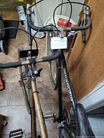 Photo of two vintage multi-speed bicycles locked side-by-side, showing black RS2000 bike and tan Sureflight bike from frontal angle.