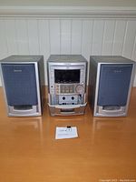 Front view of the Aiwa XR-M22HR stereo system showing central CD player and two speakers.