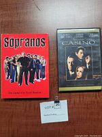 Front covers of The Sopranos Complete First Season DVD box set and Casino 10th Anniversary DVD case side by side on table with auction lot card