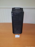 Front view of CM Storm gaming tower showing mesh front panel, USB/audio ports on top, and an integrated handle.