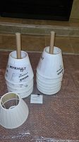 Two stacks of the unopened IKEA MYRHULT lamp shades with brand labels visible, showing quantity and condition of the lot.