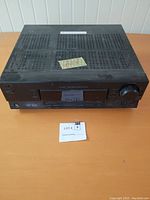 View of the top and front angled side of the black JVC RX-5030V receiver showing vented top and surface wear.