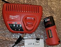 Milwaukee M12 battery charger and battery pack side by side on surface.