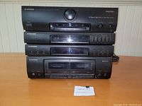 Stack of four black Pioneer audio components including RX-590 stereo receiver on top, double cassette deck, equalizer, and cassette deck below, showing front panels and controls.